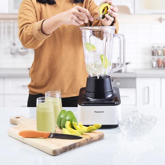 キッチンでフードプロセッサーを使って料理を楽しむ女性