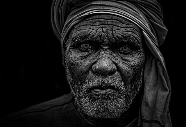 鏡を見て目元や口元のシワに悩む女性